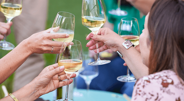 Ambiance chaleureuse : groupe avec verres de vin blanc.