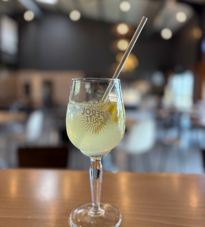 Un verre de cocktail Aperol Spritz dans un bar à l'esprit bistrot chaleureux.