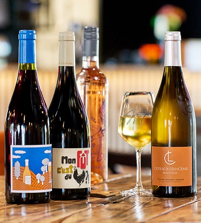Bouteilles de vin rouge, rosé et blanc dans un bar à vin, esprit bistrot chaleureux.
