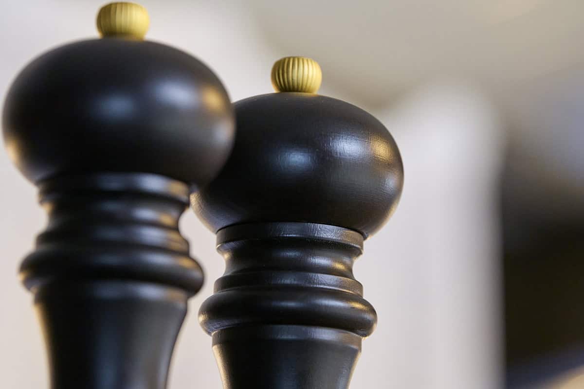 Deux moulins à poivre en bois noir avec accessoires dorés