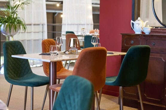 Table dressée dans un restaurant avec des chaises vertes et orange